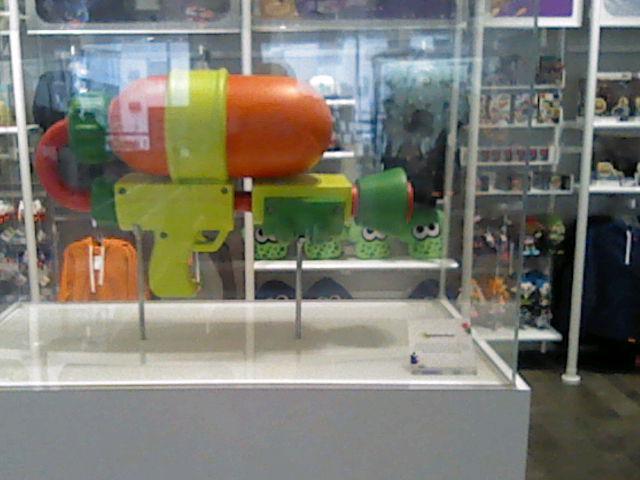 A Splattershot from Splatoon encased in glass at the Nintendo store in NYC. Shot on New 3DS XL.
