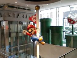 Mario cheerfully hangs off the edge of a flagpole at the Nintendo store in NYC. Shot on New 3DS XL.
