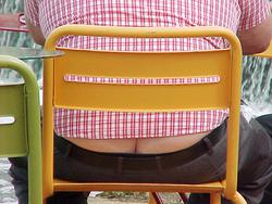 The cleft of a man's buttocks visible between his shirt and trousers